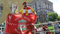 Fans Liverpool berpose dengan piala Liga Champions yang dipamerkan di Kiev, Ukraina , Kamis (24/5). Liverpool akan menghadapi Real Madrid di laga final Liga Champions. (Sergei SUPINSKY/AFP)