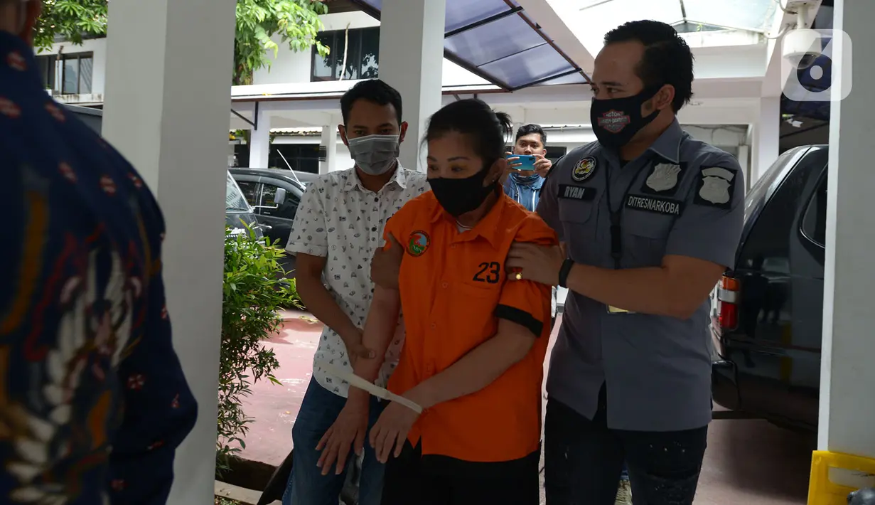 Polisi menggelandang tersangka kasus narkoba di Apartemen Kalibata City saat konferensi pers, Polda Metro Jaya, Jakarta, Rabu (15/7/2020). Dit Narkoba Polda Metro Jaya meringkus wanita berinisial TI alias II dengan barang bukti 15.000 butir pil ekstasi dan 5.500 happy five. (merdeka.com/Imam Buhori)