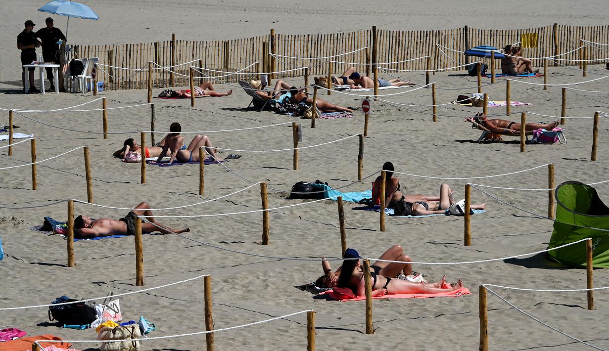 Orang-orang berjemur menikmati matahari di Sunset Beach dengan area terpisah untuk mematuhi jaga jarak di La Grande-Motte, Prancis, Selasa (26/5/2020). Ukuran area pemisah berupa kotak ini pun beragam yang dapat ditempati oleh dua, empat, atau enam orang. (Pascal GUYOT/AFP)