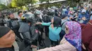 Sejumlah massa yang tergabung dalam Gerakan Pribumi Bersatu berbincang dengan Polisi dari kesatuan Brimob saat gelar doa bersama di depan kantor Bawaslu, Jakarta, Jumat (24/5/2019). Mereka datang untuk mendoakan para demonstran yang meninggal saat aksi 21-22 Mei. (Liputan6.com/Herman Zakharia)