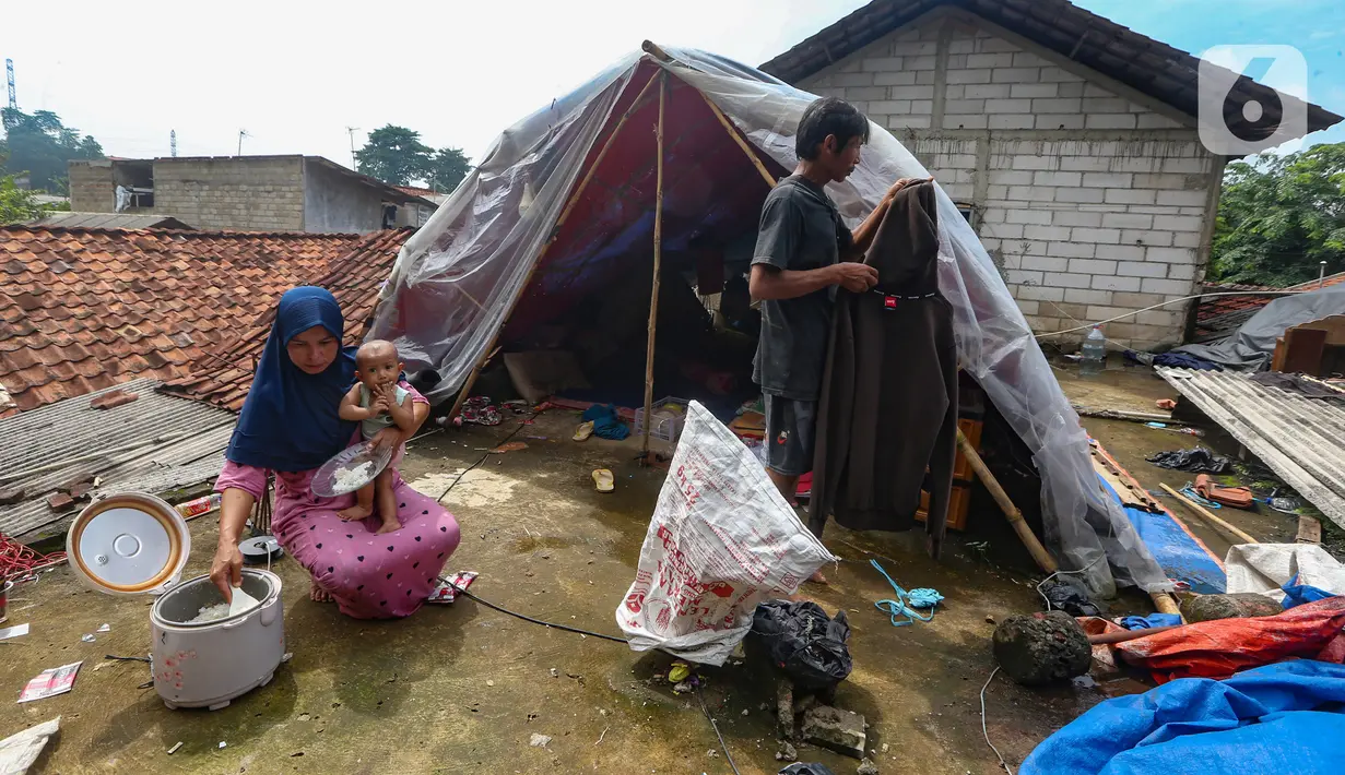 Warga beraktivitas pada tenda darurat yang dibangun di atas rumah pasca banjir melanda kawasan Pejaten Timur, Jakarta Selatan, Senin (8/1/2024). (merdeka.com/Arie Basuki)