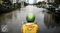 Pengendara motor berhenti sebelum melintasi genangan air di kawasan Kelapa Gading, Jakarta, Jumat (26/2/2016). Hujan deras yang mengguyur Ibukota membuat beberapa ruas jalanan tersendat. (Liputan6.com/Faizal Fanani)