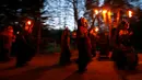 Sejumlah peserta mengenakan kostum iblis membawa obor saat mengikuti parade tardisional Perchtenlauf di Osterseeon dekat Munchen, Jerman (17/12). Acara ini bertujuan untuk mengusir hantu-hantu musim dingin. (Reuters/Michaela Rehle)