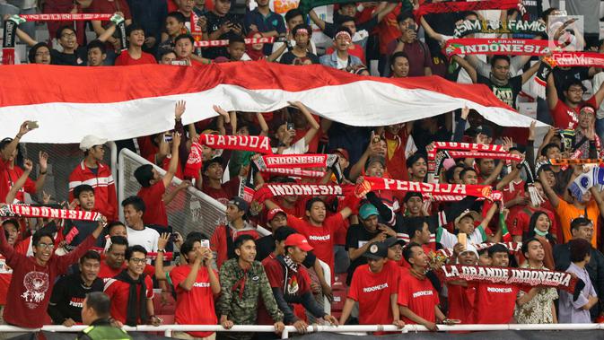 Suporter membentangkan bendera Merah Putih jelang menyaksikan laga Timnas Indonesia U-19 melawan Chinnese Taipei pada penyisihan Grup A Piala AFC U-19 2018 di Stadion GBK, Jakarta, Kamis (18/10). Indonesia unggul 3-1. (Liputan6.com/Helmi Fithriansyah)