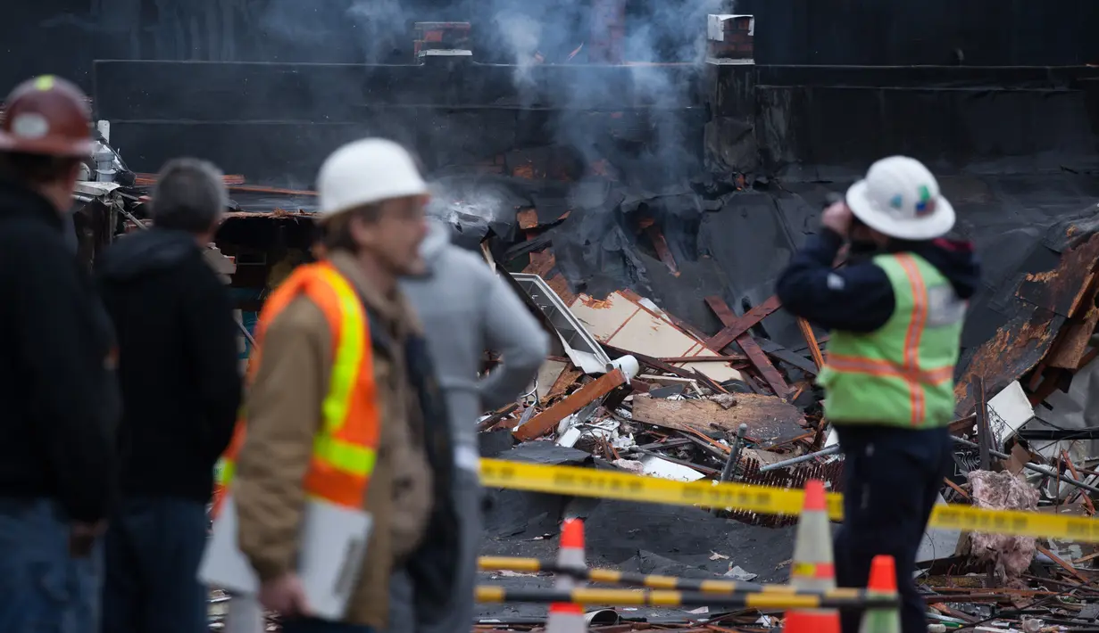 Sejumlah petugas berada di lokasi ledakan gas alam yang mengguncang Seattle, Washington, Rabu (9/3). Sembilan orang pemadam kebakaran mengalami luka-luka dan dilarikan ke rumah sakit akibat kejadian tersebut. (Matt Mills McKnight/Getty Images/AFP)