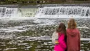 Warga menyaksikan seekor salmon melompati bendungan saat bermigrasi di Sungai Humber di Toronto, Kanada, 18 Oktober 2020. Setiap musim gugur, ribuan ikan salmon di banyak sungai di Ontario berenang menuju ke hulu untuk bertelur, menarik perhatian warga juga para pemancing. (Xinhua/Zou Zheng)