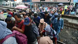 Penumpang kereta commuter line menyeberang rel kereta di Stasiun Manggarai, Jakarta, Selasa (22/1). PT. Kereta Commuter Indonesia (KCI) menutup jalur 10 di Stasiun Manggarai guna mempercepat revitalisasi yang sedang dilakukan. (Merdeka.com/Imam Buhori)