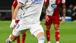 Pemain Real Madrid Karim Benzema melakukan tendangan penalti dan mencetak gol ke gawang Celta Vigo pada pertandingan Liga Spanyol di Stadion Santiago Bernabeu, Madrid, Spanyol, 12 September 2021. Karim Benzema mencetak hattrick saat Real Madrid mengalahkan Celta Vigo 5-2. (GABRIEL BOUYS/AFP)