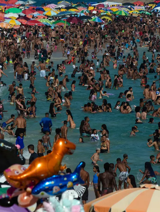 Orang-orang menyegarkan diri di pantai Macumba, saat gelombang panas di Rio de Janeiro, Brasil pada hari Minggu, (24/9/2023). (Tercio Teixeira/AFP)