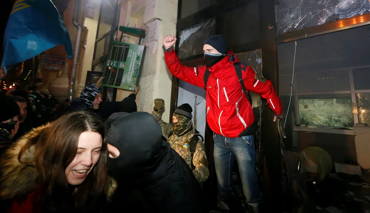 Para demonstran saat menyerang bank Rusia, Sberbank di Kyiv, Ukraina, (21/11). Aksi dilakukan untuk memperingati tragedi kerusuhan 2014 yang menyebabkan lebih dari 100 warga Ukraina tewas. (REUTERS/Valentyn Ogirenko)