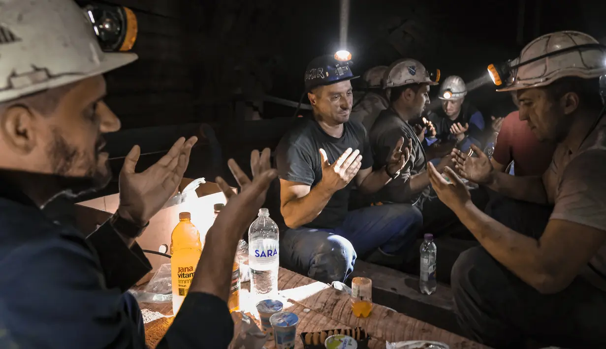 Penambang batu bara Bosnia berdoa setelah berbuka puasa di bawah tanah di sebuah tambang di Zenica, Bosnia, Kamis (29/5/2021).  Di dalam lubang tambang, orang tidak dapat melihat matahari terbenam, tetapi para penambang melihat jam tangan dan smartphone mereka untuk mengetahui waktu berbuka puasa. (