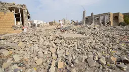 Seorang pria berjalan di reruntuhan bangunan pusat kebudayaan yang dikelola pemerintah Yaman setelah serangan udara Saudi di kota pelabuhan Laut Merah di Hodeidah, Yaman (2/9). (REUTERS/Abduljabbar Zeyad)