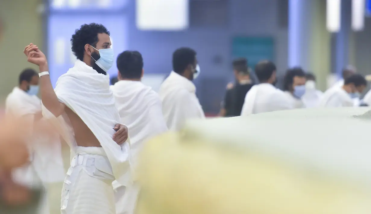 Jemaah haji melangsungkan lontar jumrah dengan mengenakan masker untuk menghindari penularan COVID-19 di Mina, Arab Saudi, Jumat (31/7/2020). Ritual melempar batu ke pilar ini menjadi simbol merajam setan. (Saudi Ministry of Media via AP)