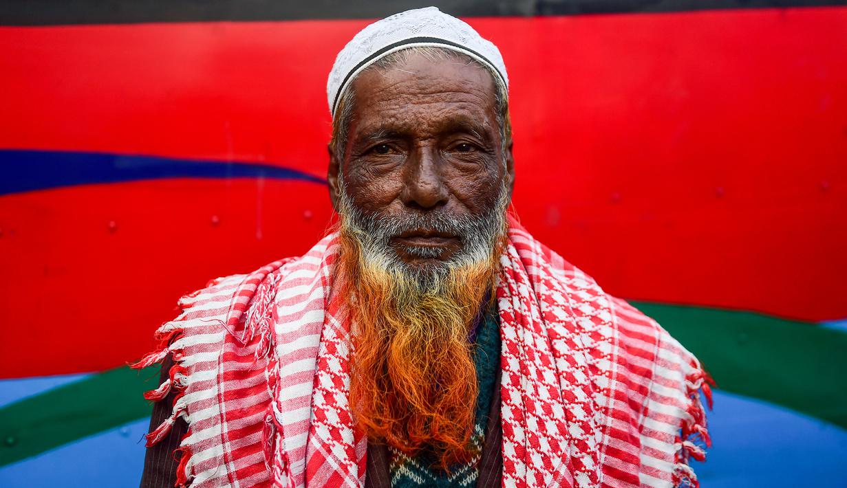 Dalam gambar yang diambil pada 24 Desember 2018, seorang pria bernama Montajur Rahman berpose dengan janggut oranye di Dhaka. Penampilan mereka ini didorong juga dengan kepercayaan terhadap tulisan-tulisan agama yang mengatakan bahwa Nabi Muhammad mengecat rambutnya. (MUNIR UZ ZAMAN / AFP)