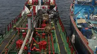 Dua kapal berjenis motor tanker dan kapal ikan yang diamankan petugas Badan Keamanan Laut (Bakamla) RI di perairan Teluk Jakarta, Jumat (1/2). Kapal tanker itu diduga telah melakukan transfer BBM ke kapal ikan sekitar 41 ton. (Liputan6.com/Angga Yuniar)