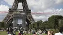 Jet dari angkatan udara Prancis Patrouille de France terbang di atas Menara Eiffel dan melewati zona penggemar Olimpiade di Paris, Minggu (8/8/2021). Pesta olahraga terbesar dunia itu pun akan kembali digelar pada 2024 mendatang di Paris, Prancis. (AP Photo/Adrienne Surprenant)