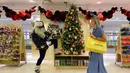 Pengunjung melintasi pohon natal di toko Selfridges, London, Senin (6/8). Selfridges yang meruapak salah satu toko terkenal di Inggris sudah membuka gerainya yang berisi ratusan ornamen dan perlengkapan natal pada bulan Agustus. (AP/Robert Stevens)