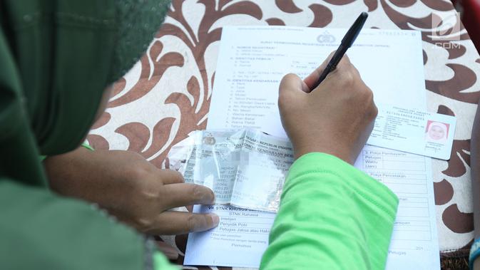 Warga mengisi formulir untuk membayar pajak kendaraan bermotor di gerai Samsat Keliling Car Free Day, Jakarta, Minggu (21/10). Agar bisa membayar pajak ini cukup menggunakan STNK dengan nama yang tertera harus sesuai KTP. (Liputan6.com/Angga Yuniar)