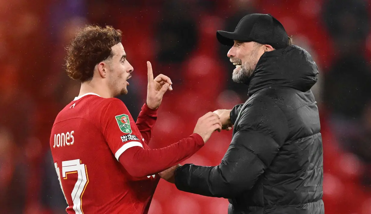 Jurgen Klopp (kanan) memberi selamat kepada Curtis Jones setelah meraih kemenangan di akhir pertandingan sepak bola perempat final Piala Liga Inggris antara Liverpool melawan West Ham United di Anfield, Liverpool, barat laut Inggris, pada 20 Desember 2023. Liverpool menang 5-1 atas West Ham United. (Oli SCARFF/AFP)