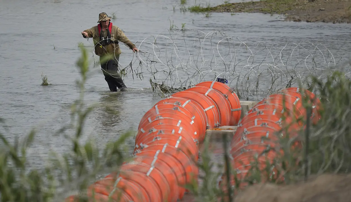 Pemasangan tersebut sebagai upaya untuk mencegah para migran menyeberangi sungai yang berbahaya itu untuk masuk ke Amerika Serikat secara ilegal. (AP Photo/Eric Gay)
