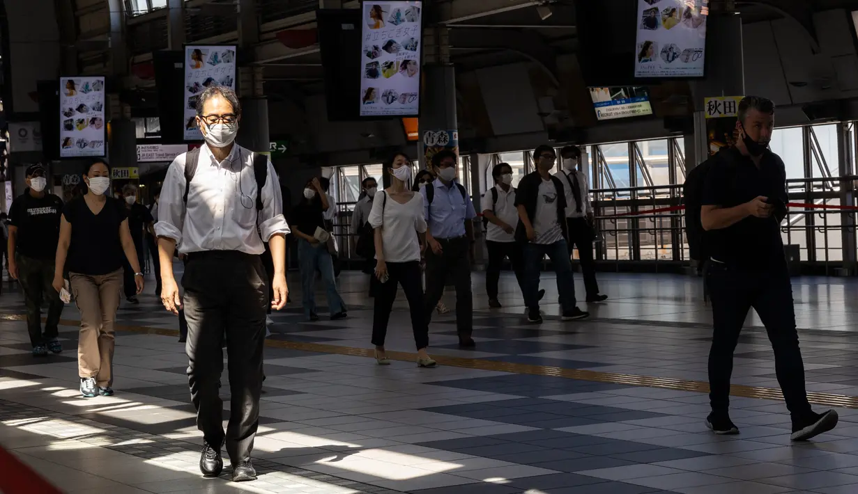 Komuter memakai masker di stasiun kereta api di Tokyo saat keadaan darurat virus corona tetap berlaku di kota itu pada Selasa (10/8/2021).  Pemerintah Metropolitan Tokyo mengonfirmasi 2.884 kasus baru covid-19 pada Senin, 9 Agustus 2021. (Yuki IWAMURA / AFP)