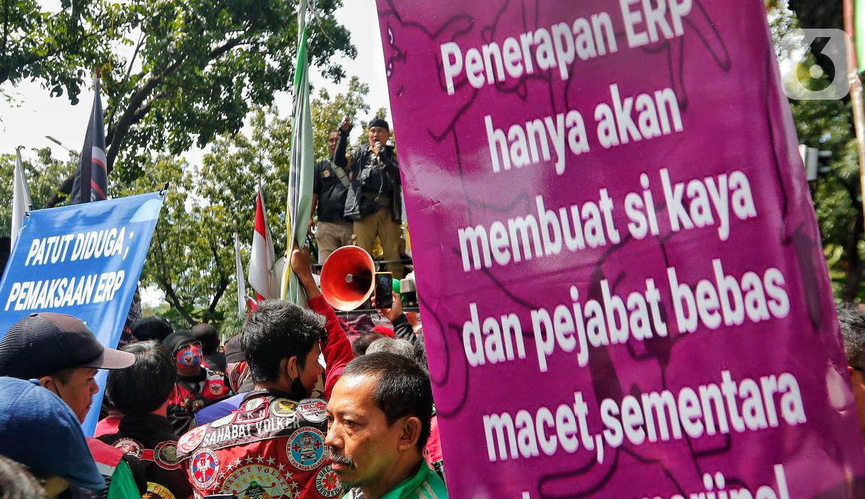 Pengemudi ojek online membentangkan spanduk tuntutan saat melakukan aksi di depan Balai Kota Jakarta, Rabu (8/2/2023). Dalam aksinya, mereka menolak penerapan jalan berbayar atau electronic road pricing (ERP) diterapkan di Jakarta. (Liputan6.com/Angga Yuniar)