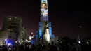 Video mapping memperlihatkan gambar bintang sepak bola Argentina Lionel Messi di "Monumento Nacional a la Bandera" di Rosario, Senin (21/11/2022). Proyeksi tersebut mengulas gambar Messi di berbagai Piala Dunia yang dimainkan dari tahun 2006 hingga sekarang. (Marcelo Manera / AFP)