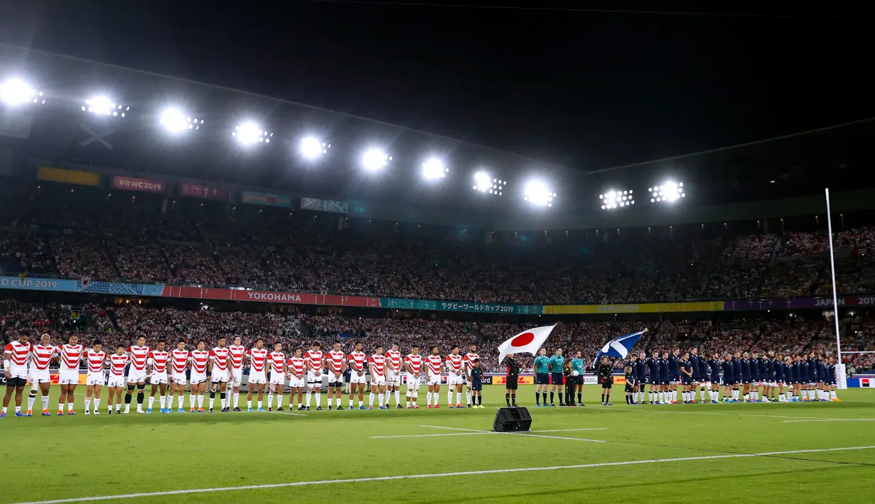 Pemain rugby Jepang dan Skotlandia berdoa bersama selama satu menit untuk korban Topan Hagibis sebelum Pertandingan Pool A Piala Dunia Rugbi 2019 di Stadion Internasional Yokohama (13/10/2019). (AFP Photo/Odd Andersen)