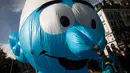 Sukarelawan memegang balon raksasa berbentuk karakter tokoh komik The Smurfs selama parade Comic Strip Festival di Brussels, Belgia, 15 September 2018. Tokoh komik terkenal dan karakter tokoh Belgia ditampilkan sepanjang jalan. (AP Photo/Francisco Seco)