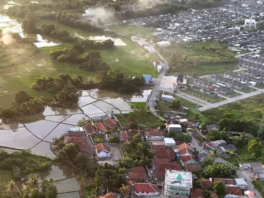 Foto udara lahan pertanian yang berdampingan dengan kawasan perumahan di Parung Panjang, Bogor, Jawa Barat, Minggu (12/1/2025). (merdeka.com/Arie Basuki)