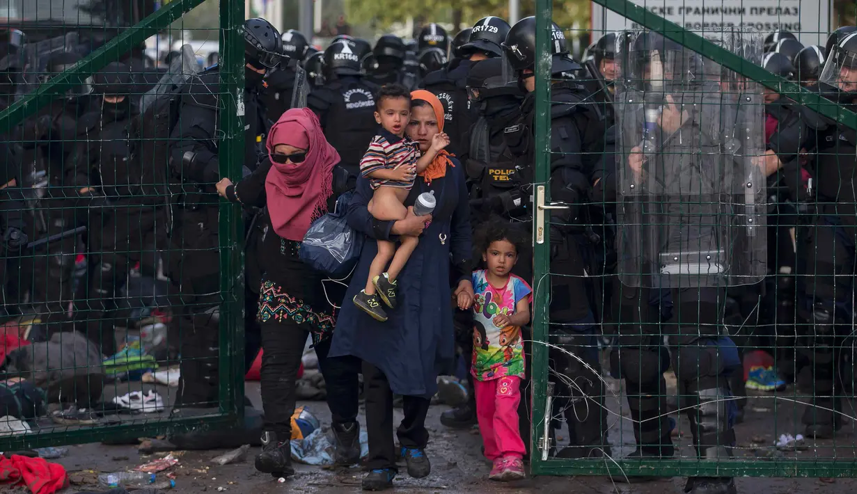 Imigran wanita dan anak-anak berhasil dievakuasi petugas dari bentrokan yang terjadi antara polisi dengan imigran yang berusaha menerobos pintu perbatasan Serbia dan Hungaria di Roszke, Rabu (16/9/2015). (REUTERS/Marko Djurica)