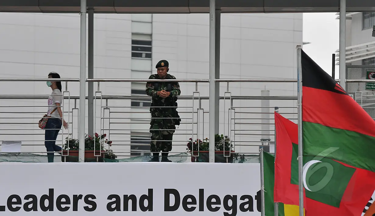 Seorang aparat keamanan terlihat berjaga di jembatan penyeberangan orang (JPO) kawasan Bundaran HI, Jakarta, Sabtu (18/4/2015). Sterilisasi dilakukan di tempat-tempat umum yang dilalui peserta Konferensi Asia Afrika (KAA). (Liputan6.com/Johan Tallo)
