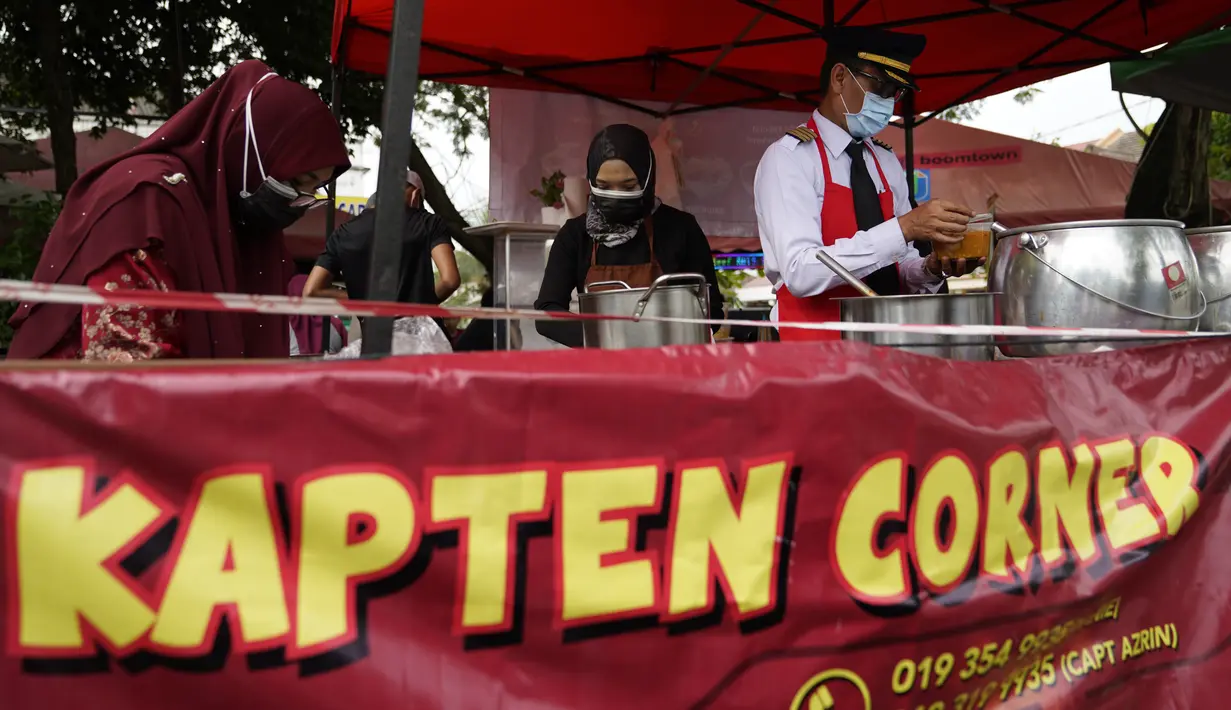 Mantan pilot Azrin Mohamad Zawawi menyiapkan mie laksa kari di warung makannya di Subang Jaya, Malaysia, Rabu (4/11/2020). M Kapten Azrin, mantan pilot maskapai Malindo itu bersama 2.200 karyawan lainnya kehilangan pekerjaan usai di-PHK pada akhir Oktober akibat virus corona (AP Photo/Vincent Thian)