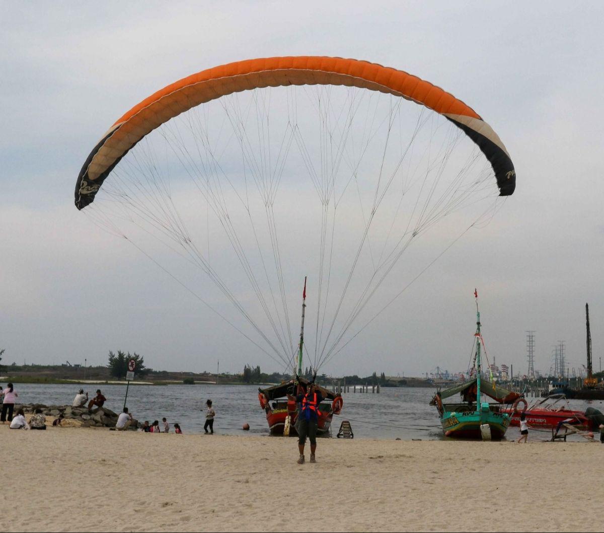 Selain berwisata dengan perahu di Pantai Ancol, pengunjung juga dapat menikmati serunya terbang bak&nbsp;paralayang  dengan parasut yang ditarik speedboat.&nbsp;Foto: Liputan6.com / Herman Zakharia
