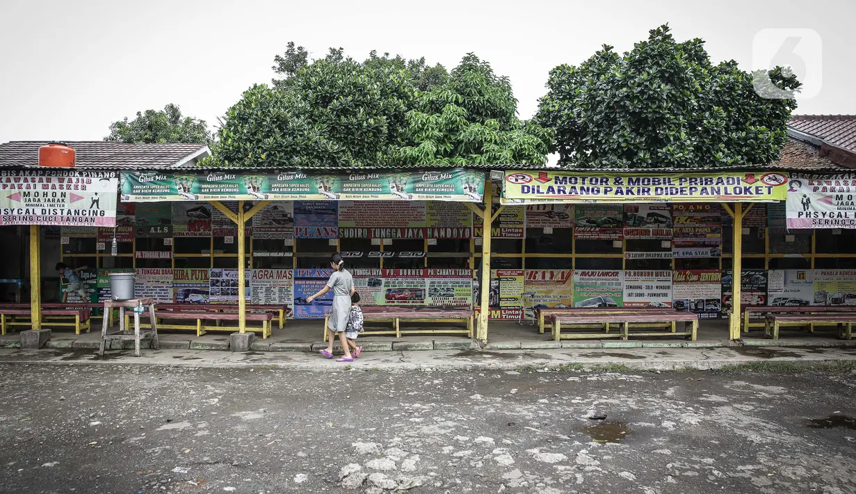Seorang perempuan dan anak kecil melintasi loket tiket yang tutup dan sepi di terminal Pondok Pinang, Jakarta, Kamis (6/5/2021). Pelayanan terminal Pondok Pinang mati suri seiring telah diberlakukan larangan mudik Lebaran mulai hari ini, 6 hingga 17 Mei 2021. (Liputan6.com/Faizal Fanani)