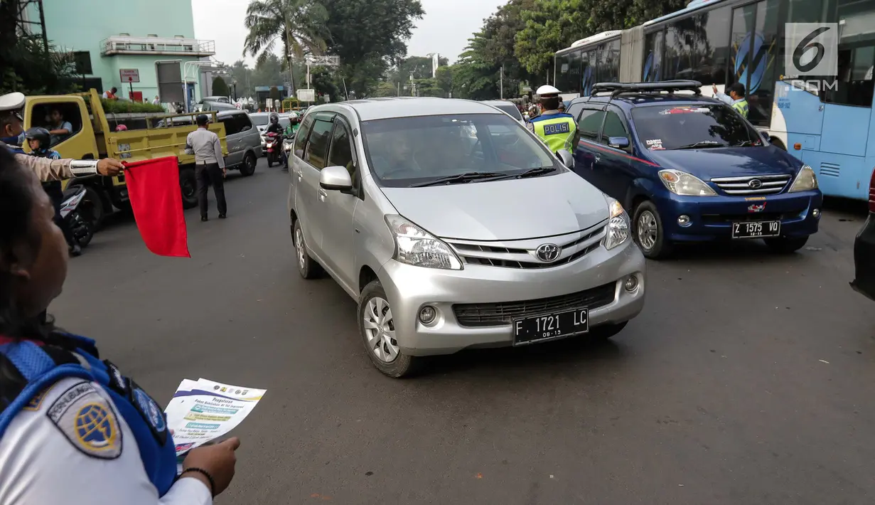 Petugas Dinas Perhubungan melakukan sosialisasi pemberlakuan sistem ganjil genap di pintu masuk Gardu Tol Cibubur 2, Jakarta, Senin (16/4). Kebijakan ini diterapkan untuk mengurai kemacetan di ruas Tol Jagorawi. (Liputan6.com/Faizal Fanani)