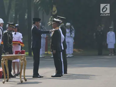 Presiden Joko Widodo (Jokowi) menyematkan tanda pangkat kepada salah satu perwira baru lulusan Akmil pada upacara Prasetya Perwira (Praspa) TNI dan Polri angkatan 2019 di Istana Merdeka, Kamis (16/7/2019). Ada 781 calon perwira yang dilantik oleh Jokowi. (Liputan6.com/Angga Yuniar)