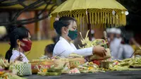 Seorang wanita bersiap berdoa untuk merayakan festival keagamaan Galungan di Pura Jagat Natha di Denpasar, di pulau Bali (16/9/2020). Galungan dirayakan umat Hindu di Bali sebagai hari kemenangan Dharma (Kebaikan) melawan Adharma (Keburukan). (AFP Photo/Sonny Tumbelaka)