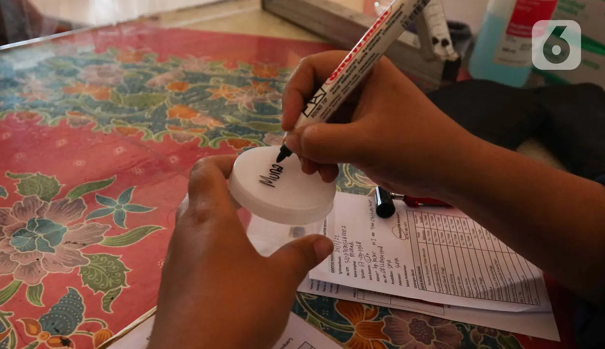 Petugas kesehatan mengecek urine pengemudi bus di Terminal Kampung Rambutan, Jakarta, Kamis (24/3/2022). Pemeriksaan kesehatan dan tes urine kepada pengemudi bus AKAP untuk mencegah terjadinya kecelakaan akibat penyalahgunaan narkoba dan obat-obatan. (Liputan6.com/Herman Zakharia)