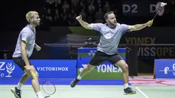 Pemain ganda putra Inggris, Ben Lane (kanan) yang berpasangan dengan Sean Vendy berusaha memotong bola pengembalian ganda putra Indonesia, Muhammad Shohibul Fikri/Bagas Maulana pada laga final kejuaraan bulu tangkis Swiss Open 2024 di St. Jakobshalle, Basel, Swiss, Minggu (24/3/2024). Ben Lane/Sean Vendy menang dua gim langsung 24-22, 28-26 untuk menjadi juara. (Keystone via AP Photo/Georgios Kefalas)