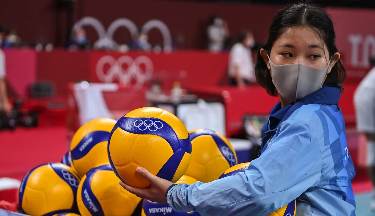 Seorang relawan menata bola selama babak penyisihan bola voli putra Olimpiade Tokyo 2020 antara Kanada dan Iran di Ariake Arena pada 28 Juli 2021. Relawan atau volunteer merupakan salah satu kunci suksesnya suatu perhelatan, tak terkecuali Olimpiade Tokyo 2020 ini. (ANDREJ ISAKOVIC/AFP)