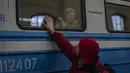 Pengungsi Ukraina di kereta api tujuan Polandia mengucapkan selamat tinggal di Lviv, 22 Maret 2022. Pada hari Selasa ketika perang Rusia yang tak henti-hentinya di Ukraina memaksa lebih banyak pengungsi untuk meninggalkan rumah mereka. (AP Photo/Bernat Armangue)