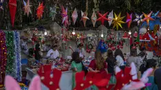 Orang-orang berbelanja suvenir Natal dari pedagang pinggir jalan di Mumbai, India, Selasa (20/12/2022). Jelang puncak perayaan Natal, warga Mumbai mulai ramai berburu ornamen dan aksesoris Natal untuk menyambut dan memeriahkan perayaan untuk umat kristiani tersebut. (AP Photo/Rafiq Maqbool)
