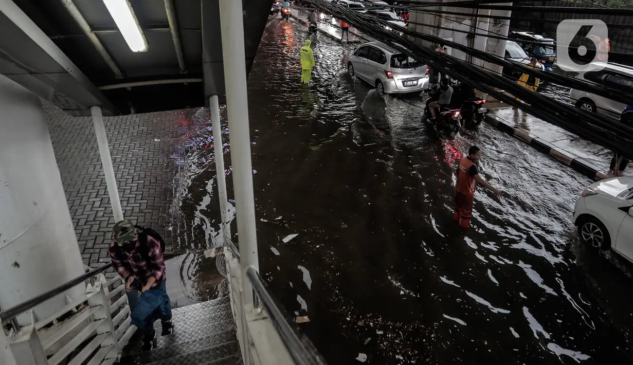 Sejumlah kendaraan menerobos Banjir yang menggenangi kawasan Seskoal - Cipulir, Jakarta, Selasa (4/4/2022). Hujan yang mengguyur wilayah Ibu Kota Jakarta mengakibatkan banjir menggenangi kawasan Simpang Seskoal, Kebayoran Lama, Jakarta. Banjir setinggi 50cm - 1 meter disebabkan saluran pembuangan berukuran kecil tersumbat. (Liputan6.com/Johan Tallo)
