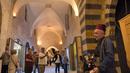 Orang-orang berjalan-jalan di "Souq Khan al-Harir" (pasar tertutup sutra) yang dibuka kembali setelah konflik bertahun-tahun di kota utara Aleppo, Suriah (29/8/2021). (AFP Photo)
