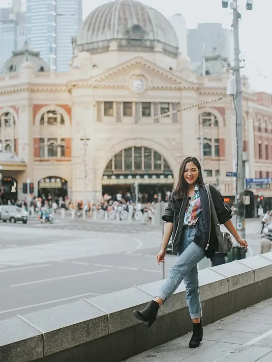 Jessica Mila tampak bahagia menikmati suasana di pusat Kota Melbourne. Berpose di depan stasiun Flinder yang ikonik, Jessica bergaya santai dengan jeans dan sepatu hitam. (Liputan6.com/IG/@jscmila)
