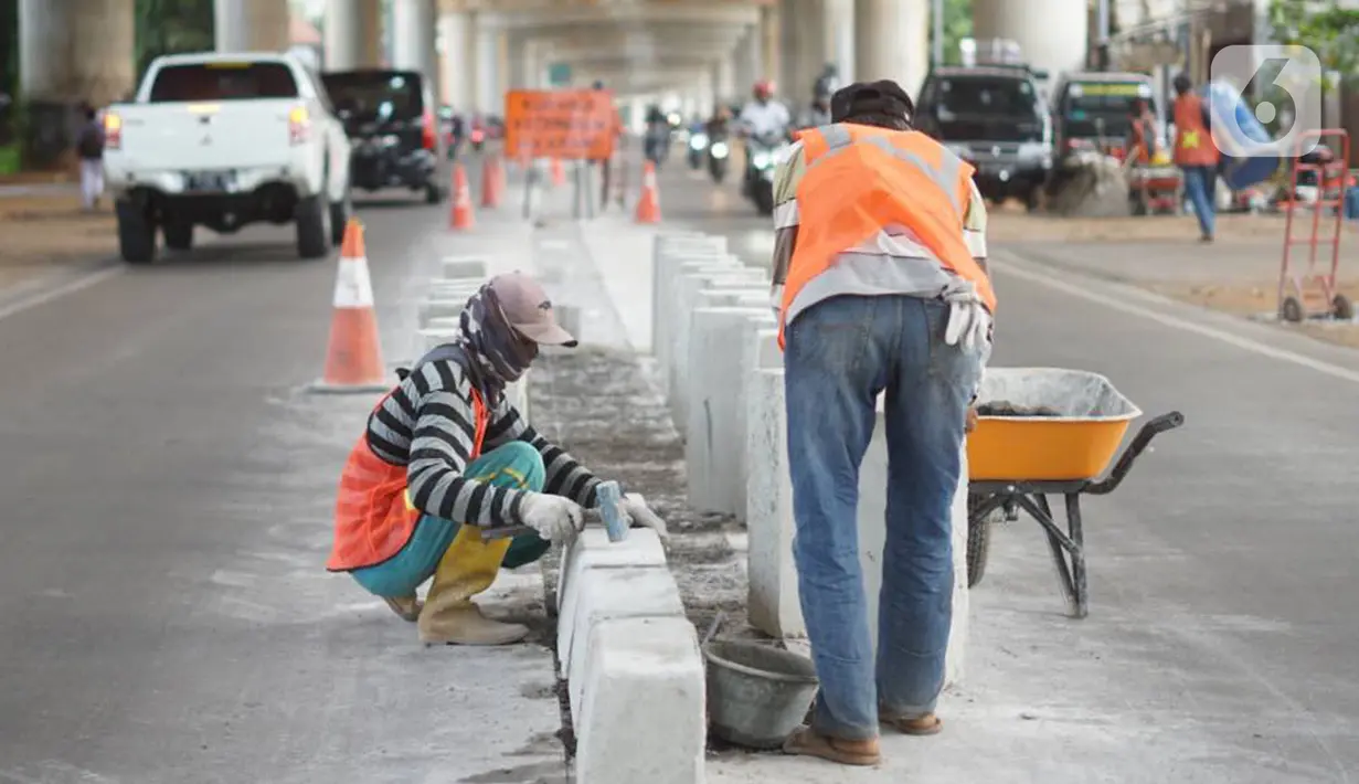 Pekerja menyelesaikan pembuatan separator atau pembatas jalan di Jalan Margasatwa, Andara, Jakarta Selatan, Kamis (21/11/2019). Separator itu dibuat guna memisahkan dua lajur sehingga meminimalisasi tingkat kecelakaan. (Liputan6.com/Immanuel Antonius)