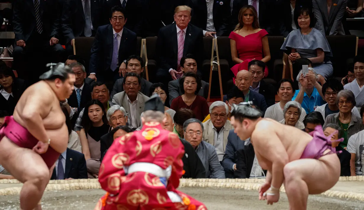 Presiden AS Donald Trump (dua kiri) didampingi PM Jepang Shinzo Abe (kiri) menyaksikan Tokyo Grand Sumo Tournament di Stadion Ryogoku Kokugikan, Tokyo, Jepang, Minggu (26/5/2019). Trump merupakan Presiden AS pertama yang menonton sumo di Jepang. (AP Photo/Evan Vucci)