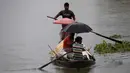 Penduduk desa melakukan perjalanan dengan perahu untuk mengungsi ketempat yang aman setelah banjir melanda kawasan distrik Morigaon di Assam, India (26/6/2020). Banjir merendam sejumlah wilayah yang dilalui Sungai Brahmaputra dan anak sungainya. (AP Photo/Anupam Nath)