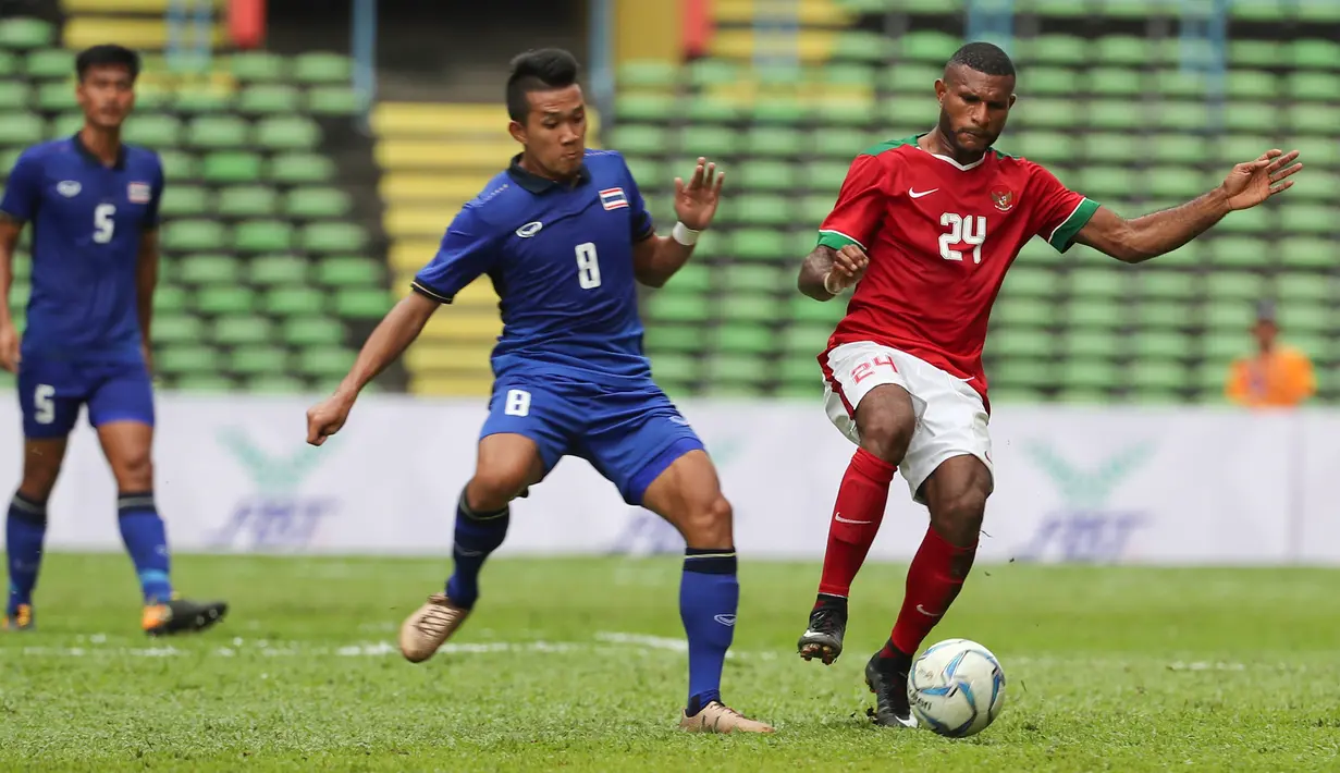 Penyerang Timnas Indonesia U-22, Marinus Mariyanto Wanewar berusaha mengontrol bola dari kawalan pemain Thailand Nopphon Phonkam saat bertanding di SEA Games 2017 di Shah Alam, Malaysia (15/8). (AP Photo / Vincent Thian)